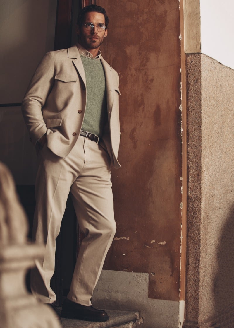 Simone Bredariol in a stone-colored suit over a green sweater on a staircase, for Boglioli's fall-winter 2026 campaign