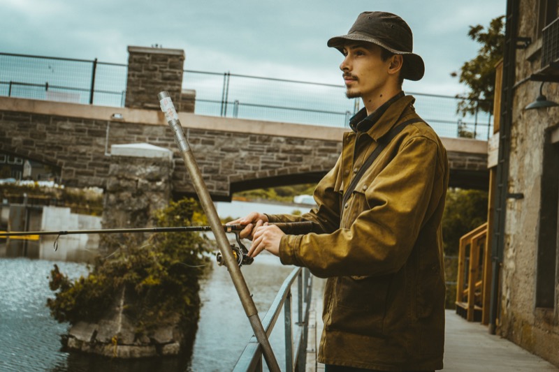 Weathered canvas and a worn bucket hat capture the rugged spirit of fisherman style at work.