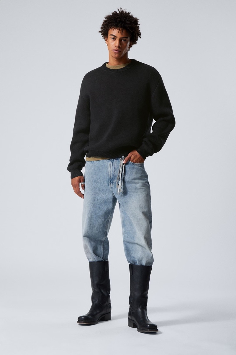 Distressed denim and black boots reframe the fisherman aesthetic with directional styling.
