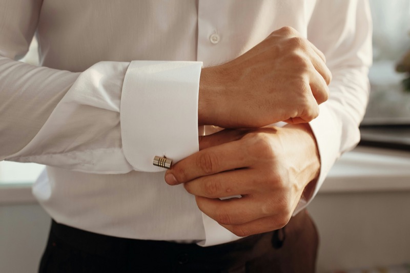 man securing cufflink