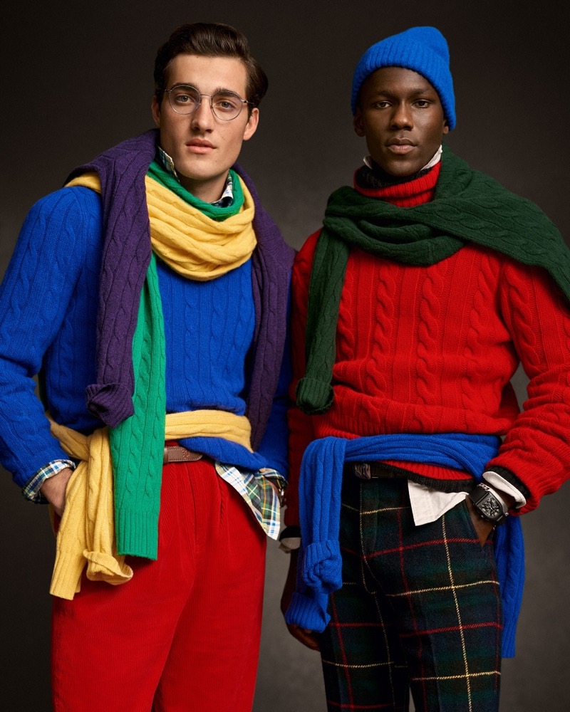 Models Adam Sattrup and Cheikh Dia wear colorful cable-knit sweaters from Polo Ralph Lauren’s holiday 2024 collection. 