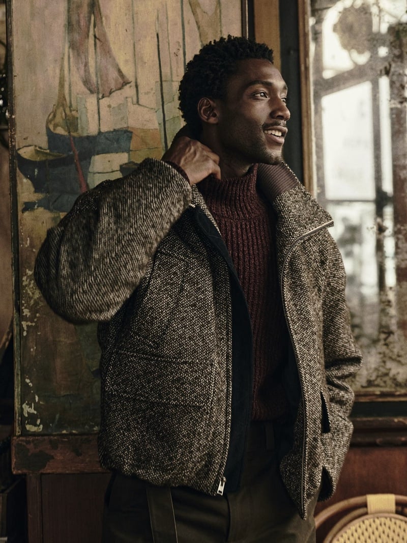 Halid Nuhu wears a textured zip jacket over a ribbed knit in a Paris café.