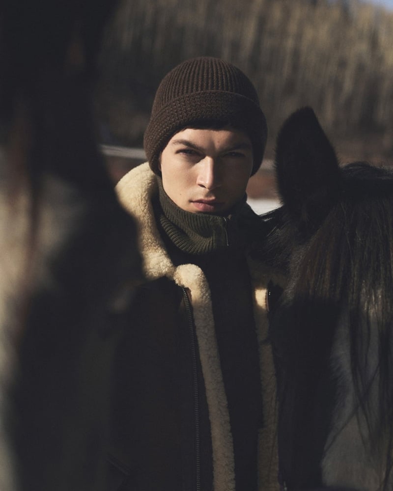 Just Verhoeff wears a brown knit cap and shearling-trimmed jacket beside a horse for Loro Piana's holiday 2026 campaign.