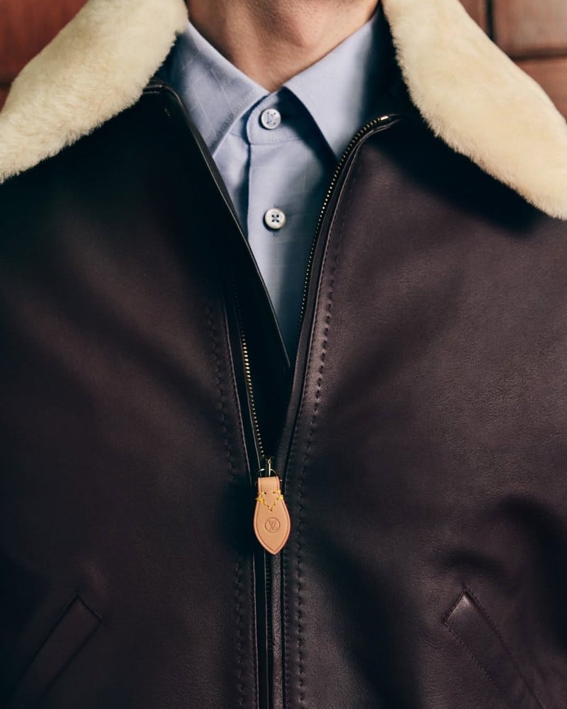 Detail of Callum Turner's leather blouson, showing its plush collar and stitched leather zip pull in the Louis Vuitton Trunk Edition campaign.