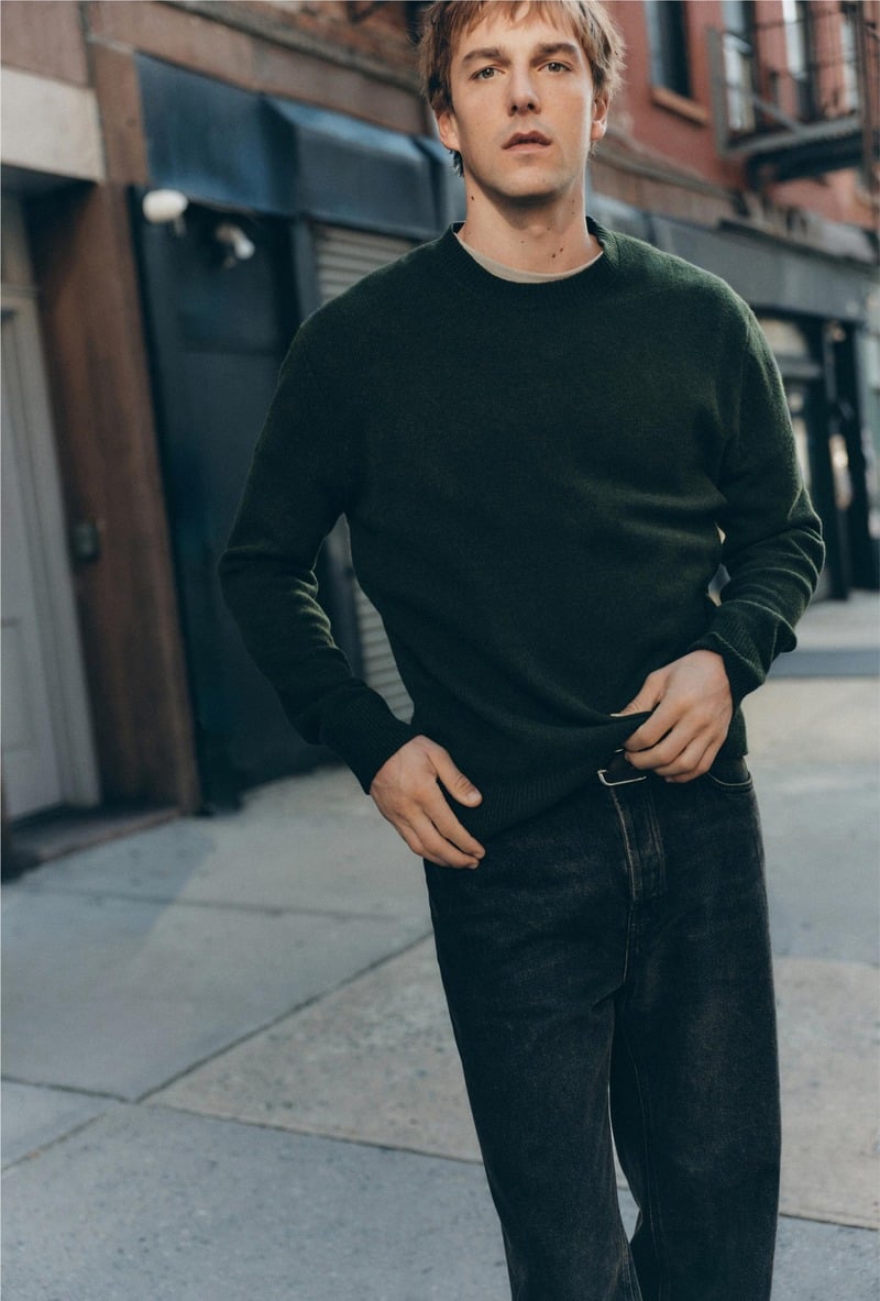 Quentin Demeester wears a dark crewneck sweater with pleated trousers outside a New York building for Massimo Dutti's fall 2026 New York edit.