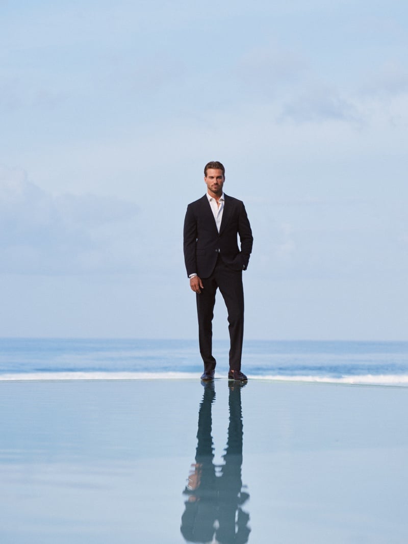 Paulo Lopes Lucio stands beside a reflective pool wearing a dark suit, white shirt and tie.