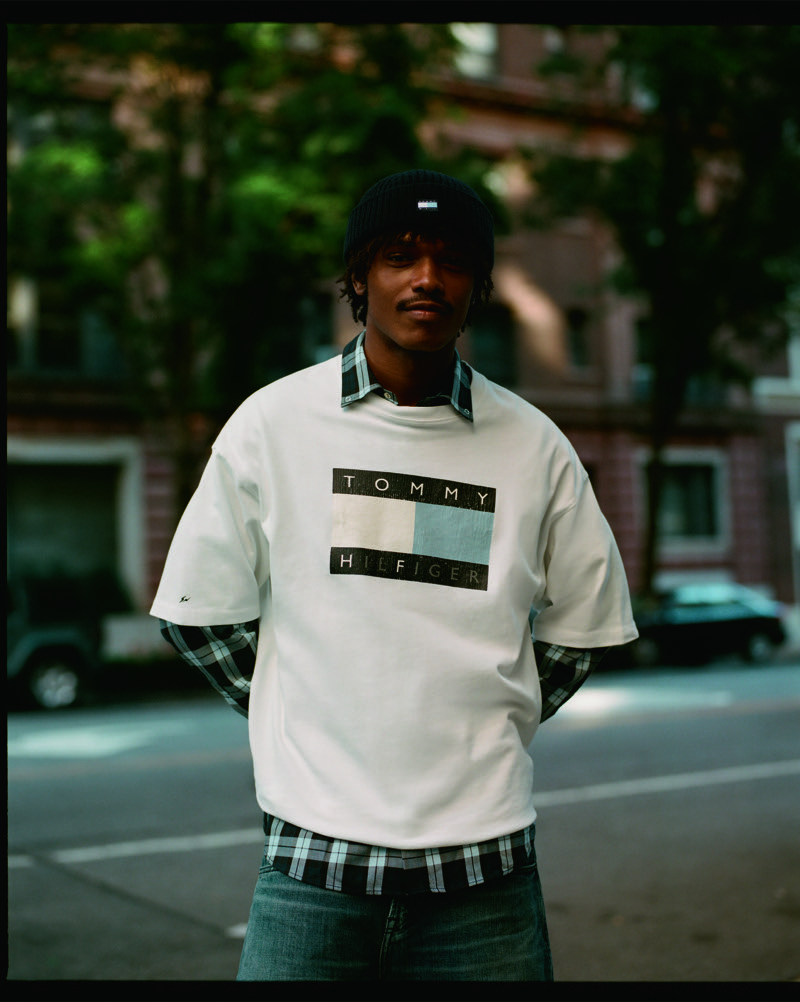 Nile Winchester wears a white Tommy Hilfiger x FRGMT logo T-shirt over a plaid shirt.
