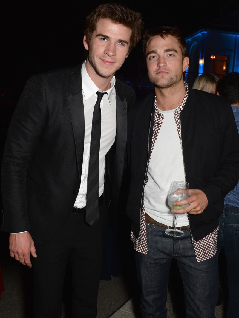 Actors Liam Hemsworth and Robert Pattinson catch up while posing for a photo together
