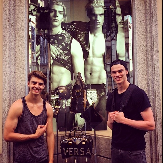 Daan van der Deen and Filip Hrivnak check out their fall/winter 2014 Versace advertisement at the label's Milano store.