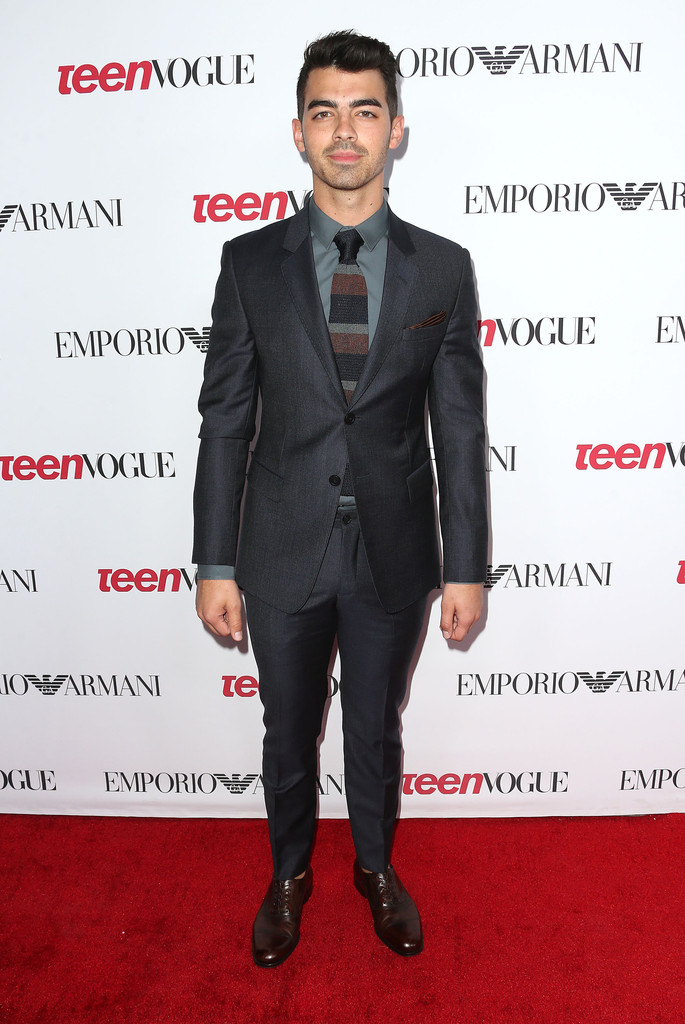 Suiting up for Teen Vogue's Young Hollywood party on September 26, 2014, Joe Jonas embraced a great trim suit as usual, finishing a charcoal ensemble with a knit striped tie.