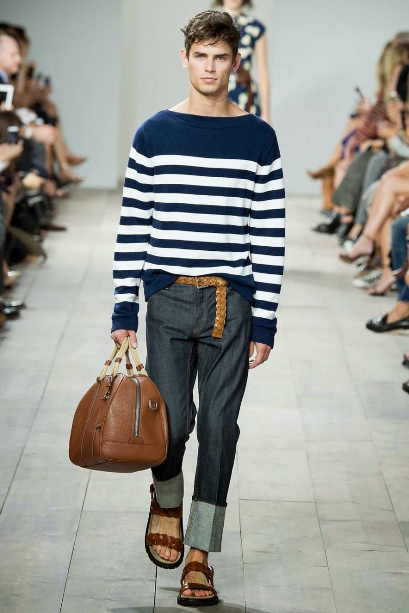 Michael Kors Spring/Summer 2015: American designer Michael Kors signs on for the denim trend, championing nautical styles as well. Here, a striped navy sweater is the ideal companion piece to straight leg denim jeans with large cuffs.
