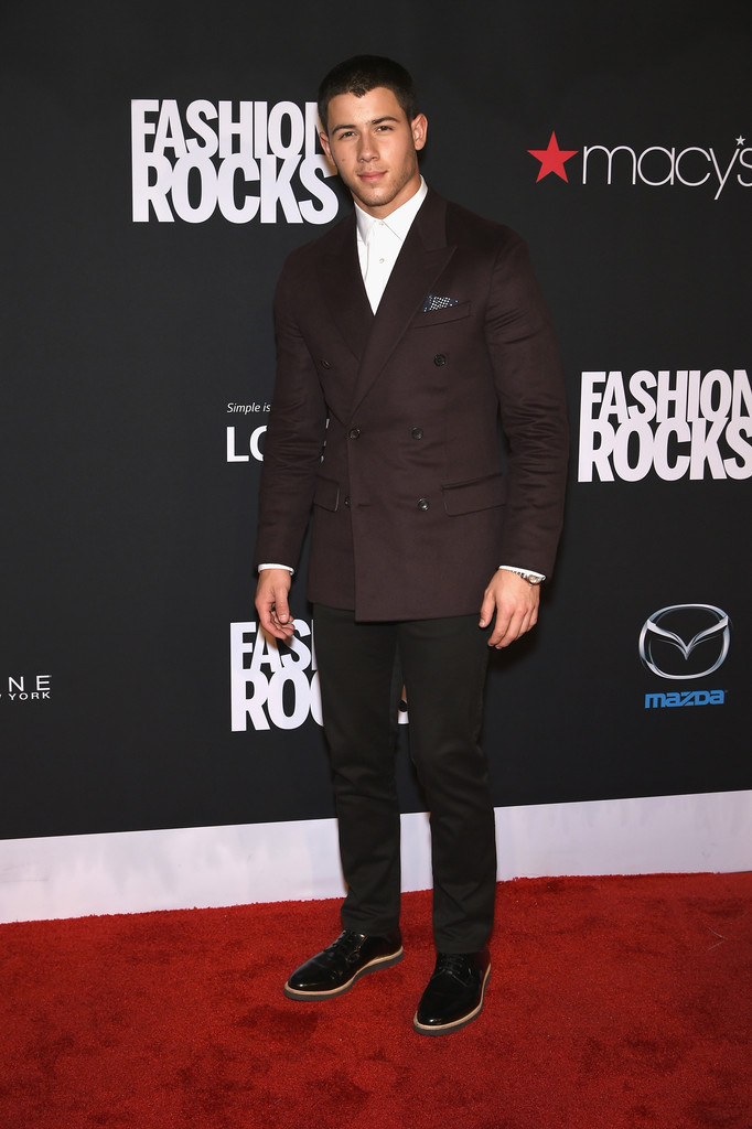 Nick Jonas hits the red carpet for Fashion Rocks in a double-breasted blazer and slim-cut trousers.