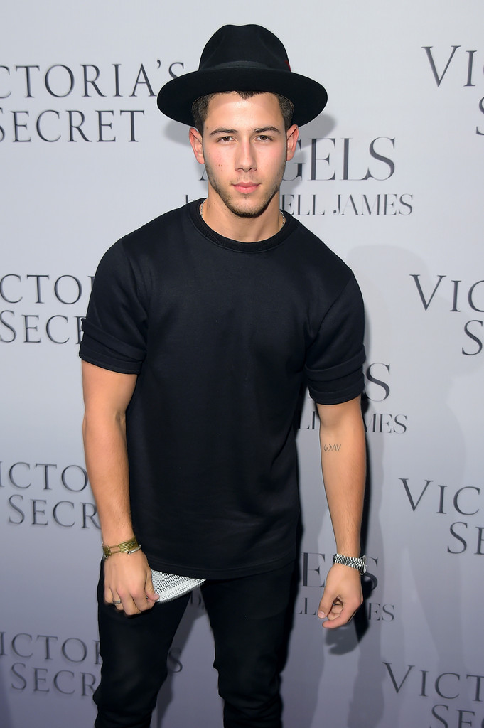 Nick Jonas wears a fedora and layered black ensemble to check out the Victoria's Secret hosted Russell James book launch on September 10th.