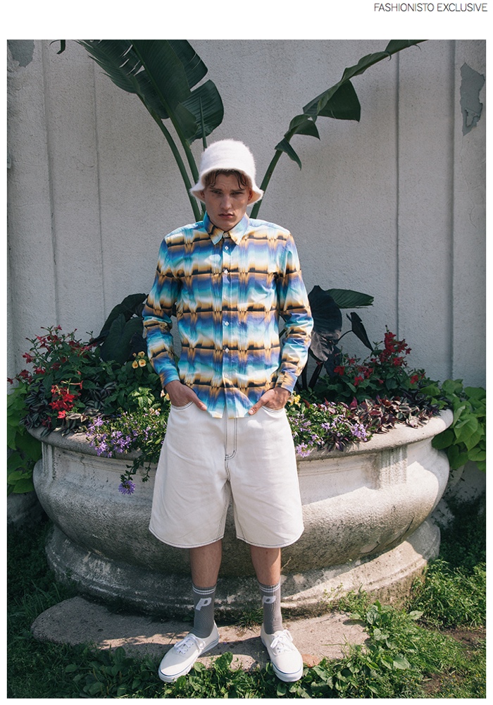 Zak wears button-down shirt Etudes Studio, denim shorts Cheap Monday, fur bucket hat stylist's own, socks Palace Skateboards and shoes VANS.