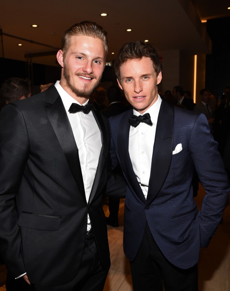 Dapper in a black tuxedo, BVLGARI brand ambassador Alexander Ludwig joins fellow actor Eddie Redmayne for a photo.