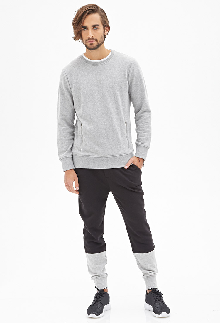 Nicolas wears black and gray color block sweatpants.