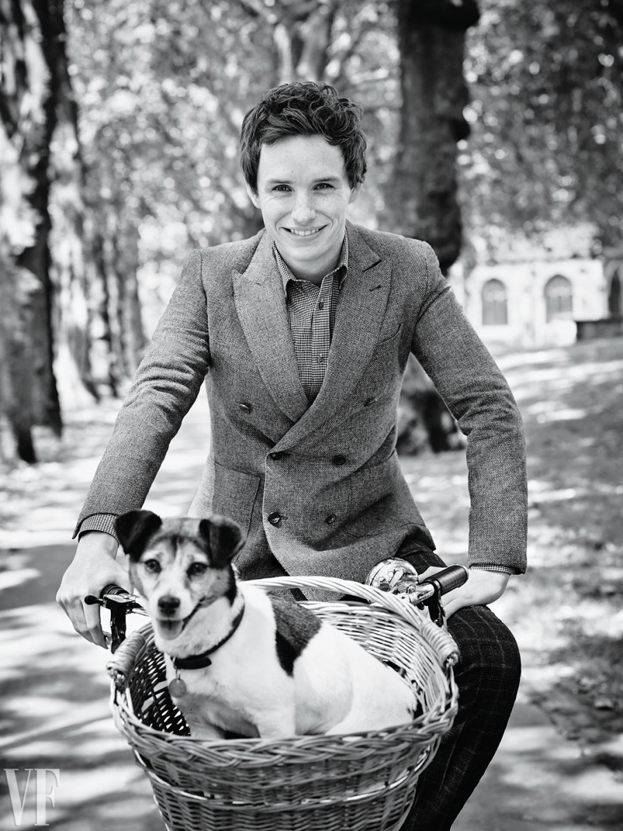 Eddie Redmayne goes for a dapper bicycle ride with a dog along for the ride. / Photo by Jason Bell. Styling by Jessica Diehl.