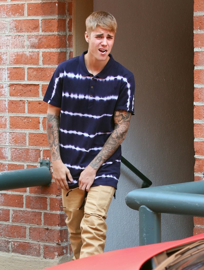 Spotted out and about in Los Angeles, California on October 13, 2014, music artist Justin Bieber paired a khaki pair of pants with Zanerobe's 'Drip Trip' tie dye polo shirt, which is available from Amazon.