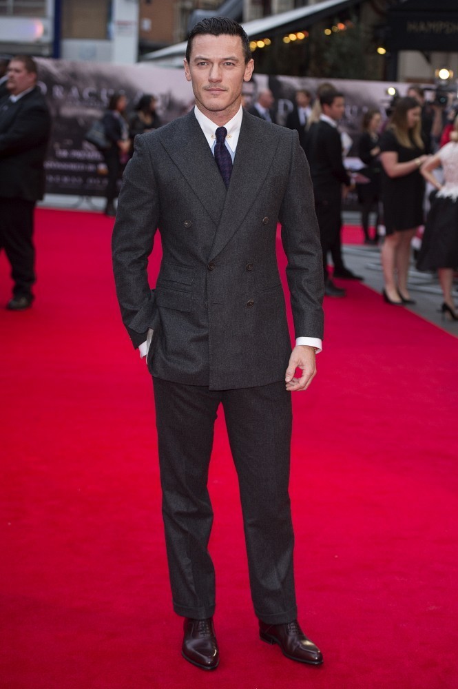 Hitting the red carpet for the London premiere of his latest movie, 'Dracula Untold', actor Luke Evans wore a charcoal double-breasted suit with a white dress shirt and purple argyle tie.