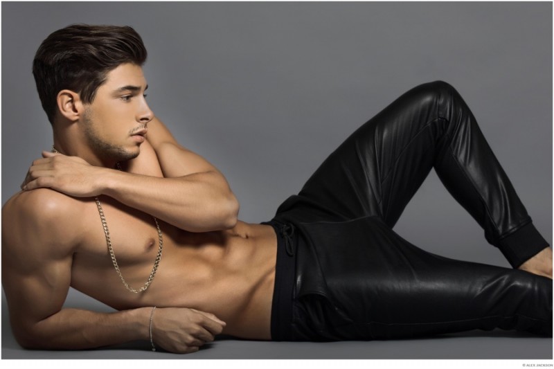 A shirtless Andrea Denver poses in leather joggers.