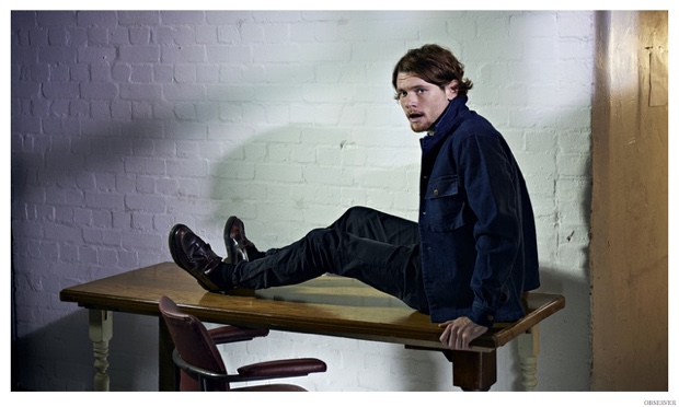 jack oconnell sitting on a table in a sparse room