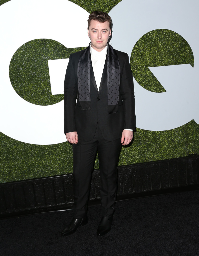 Sam Smith wears Gucci black satin peak lapel one-button Marseille tuxedo with a white shirt, black satin scarf and black leather boots.