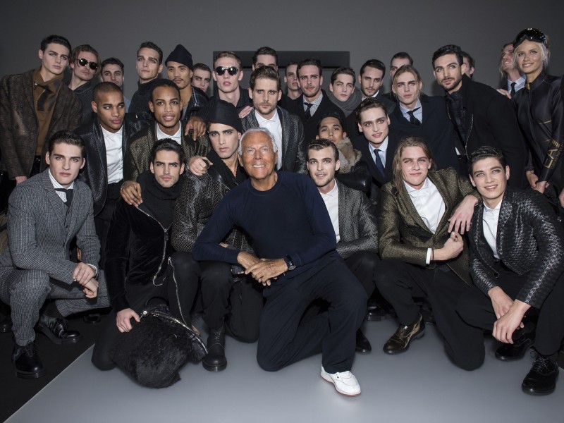 Giorgio Armani takes a photo with the models who walked for Emporio Armani's fall-winter 2015 menswear campaign.