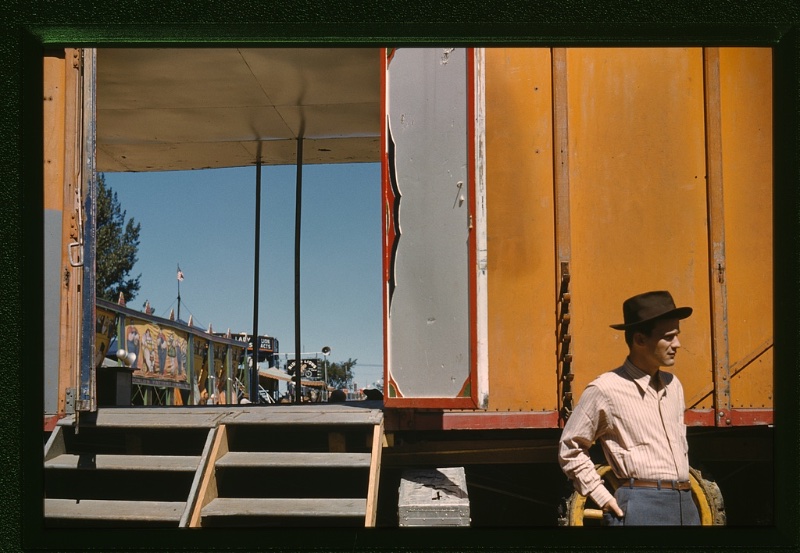 A man wears a striped shirt with trousers, a slim leather belt, and fedora at the Vermont state fair circa September 1941.
