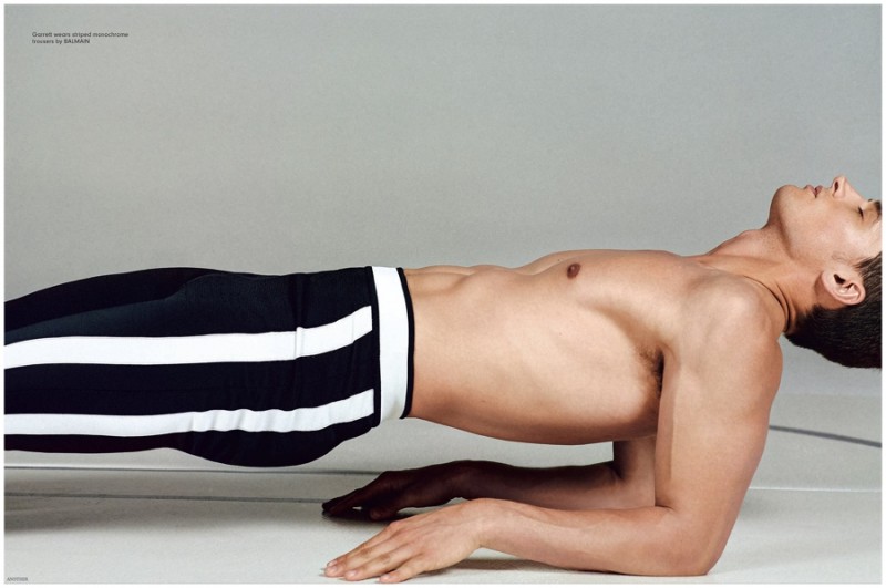 Garrett Neff shows off his strength by holding a calm pose in Balmain pants.
