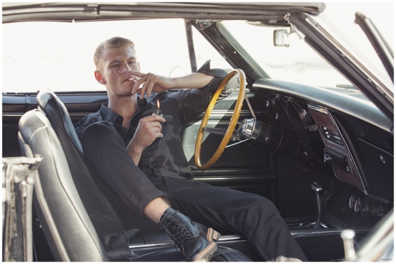 Sitting in a vintage car, Noah Teicher takes a smoke break.