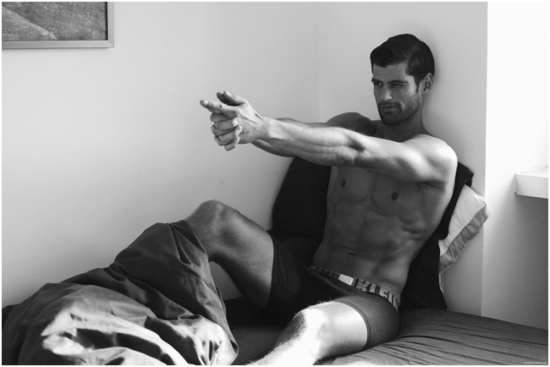 Adam Caldera poses playfully in bed.