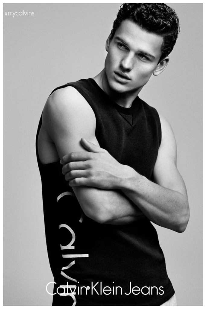 Simon Nessman poses in a Calvin Klein Jeans logo, sleeveless top.