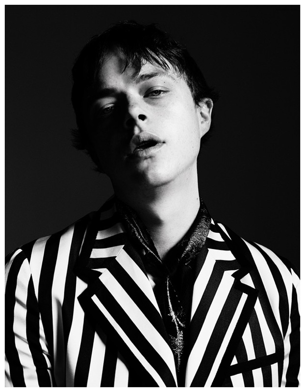 Posing for a black & white photo, Dane DeHaan wears a striped Gucci look.