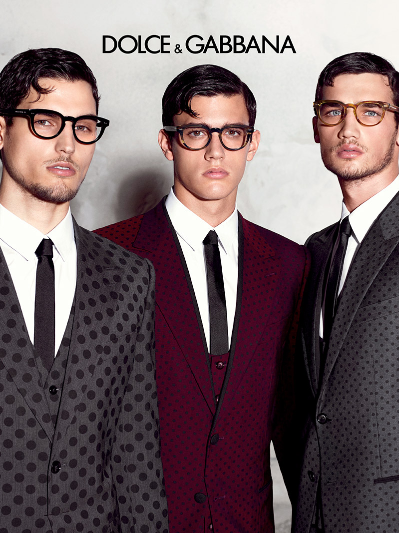 Models Travis Cannata, Xavier Serrano and Misa Patinszki dress up in Dolce & Gabbana polka dot print three-piece suits, accessorized with eyewear featuring bold frames.