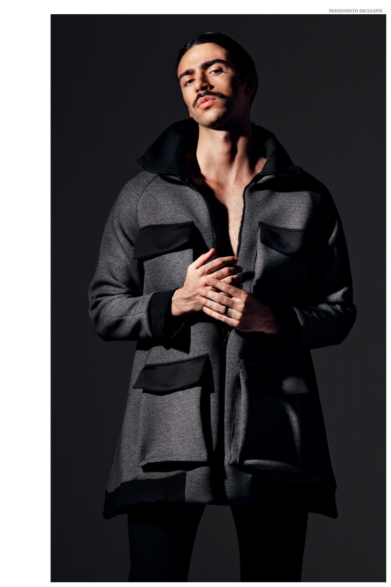 Carlos Sanjuan sports a black and gray coat with oversized pockets.