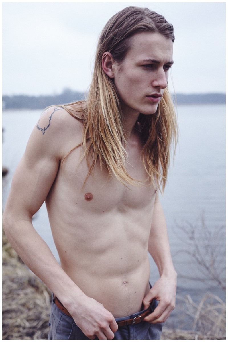 Heading outdoors, a shirtless Finn poses by a lake.