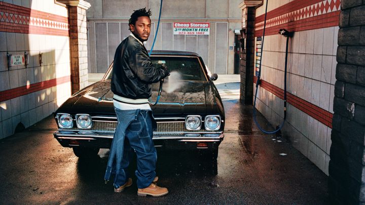 Kendrick Lamar makes a bold fashion choice in unfastened denim overalls.