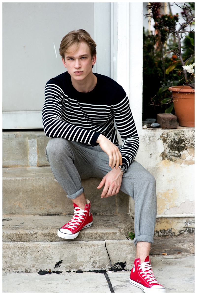 Sporting Converse and a casual ensemble from H&M, Mikal poses for an image outdoors.