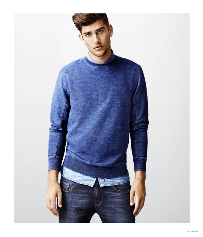 Jack Vanderhart achieves a simple denim on denim look by wearing a blue sweater over a denim shirt with jeans.