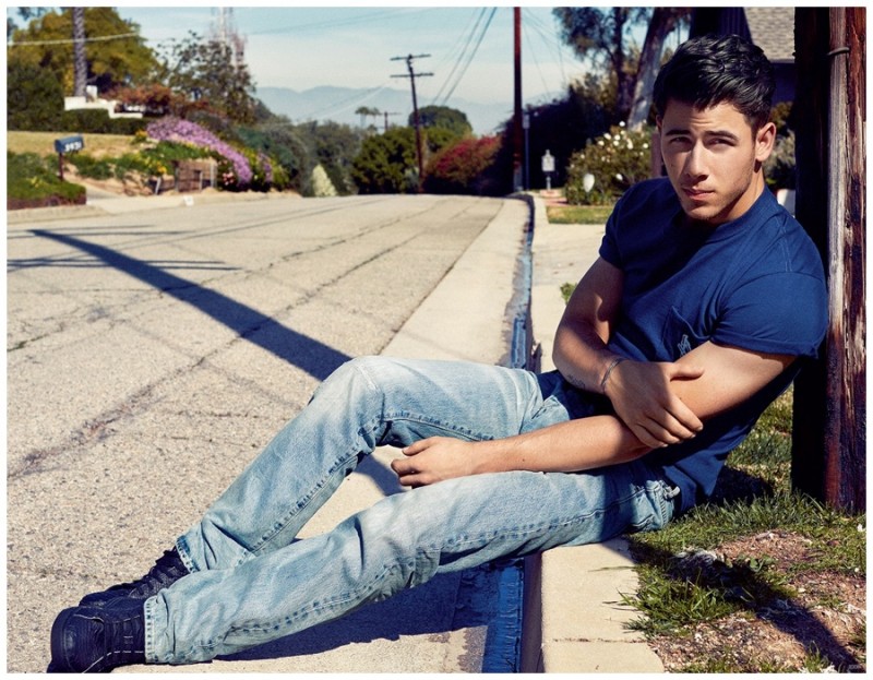 Nick Jonas goes casual in light wash denim jeans and a blue t-shirt.