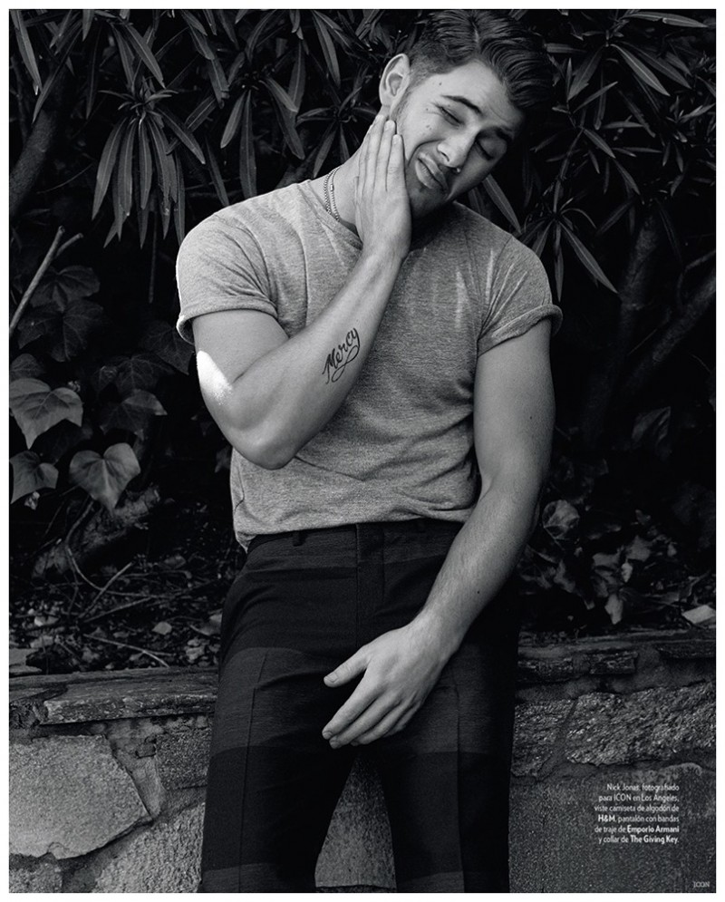 Nick Jonas rolls up the sleeves of a H&M t-shirt and wears color block trousers from Emporio Armani.