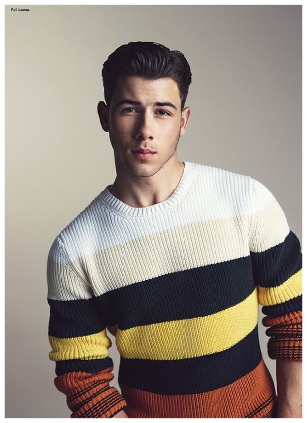Nick Jonas wears a colorful striped sweater from Loewe.