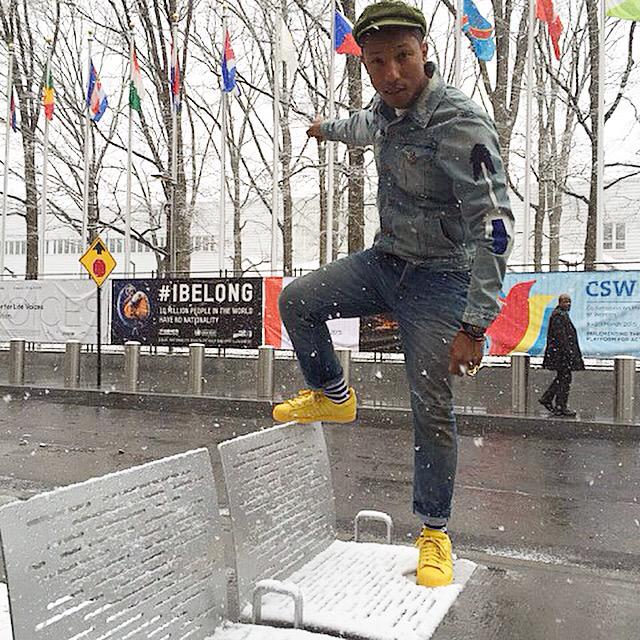 Pharrell enjoys an International Day of Happiness in his Adidas Originals Superstar yellow sneakers.