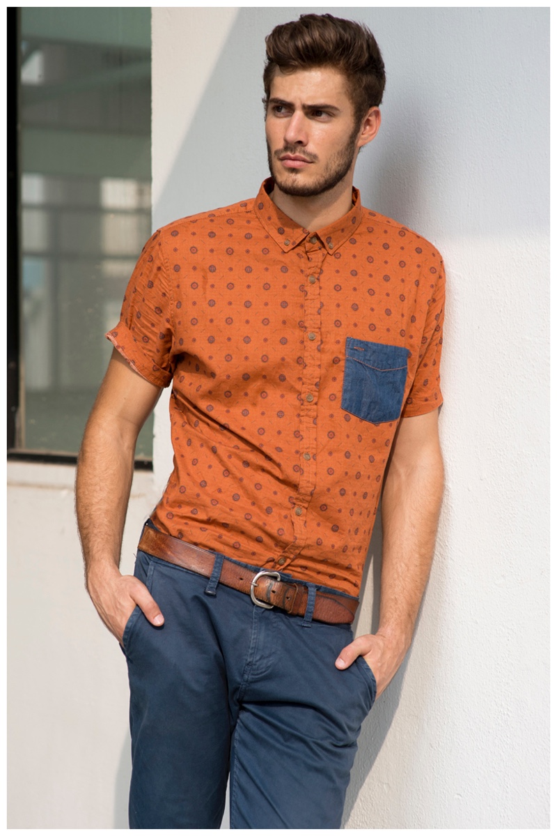 Adding a pop of color, Roelof Theunissen wears a short-sleeve print orange shirt.