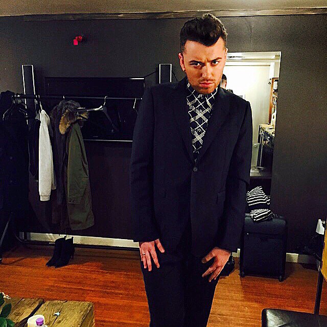 A leaner Sam Smith poses for a photo in a slim-cut suit.