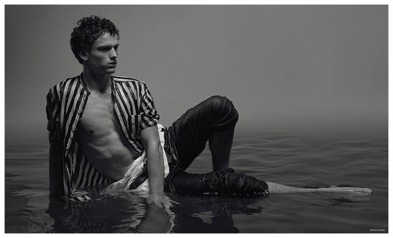 Simon Nessman relaxes in a body of water, wearing a striped Gucci top.