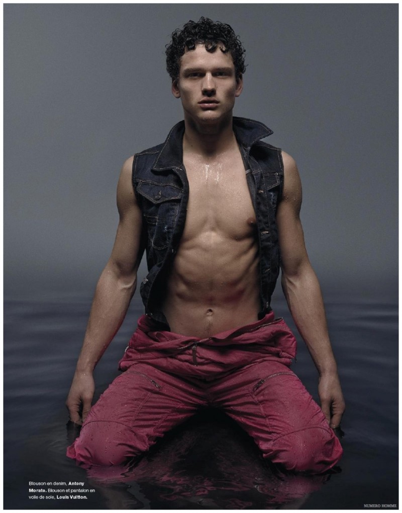 A shirtless Simon Nessman rocks an Antony Morato denim vest paired with a statement piece from Louis Vuitton.