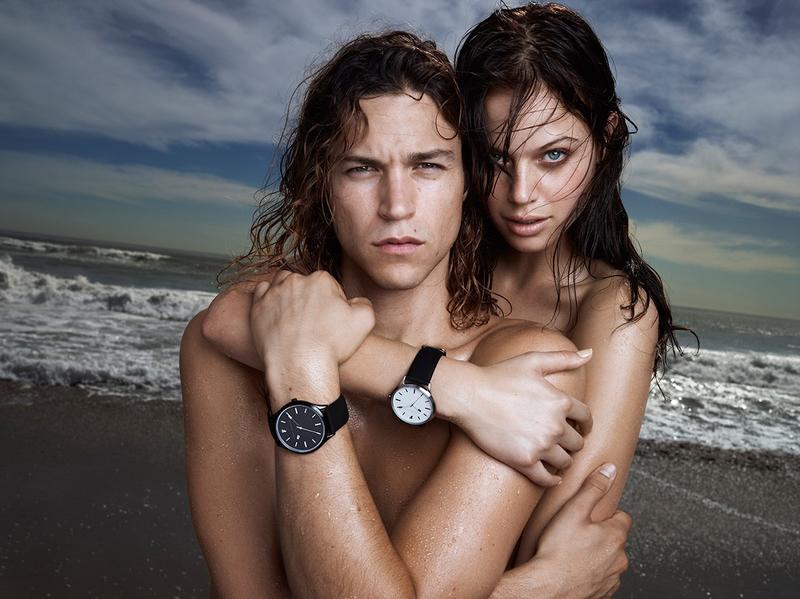 Showcasing French Connection's watches, Miles McMillan is photographed on the beach with a topless Jessica Clarke.