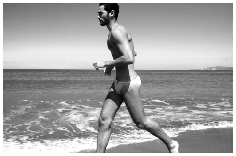 Wearing his swimsuit, Lucas Alves goes for a run along the beach.