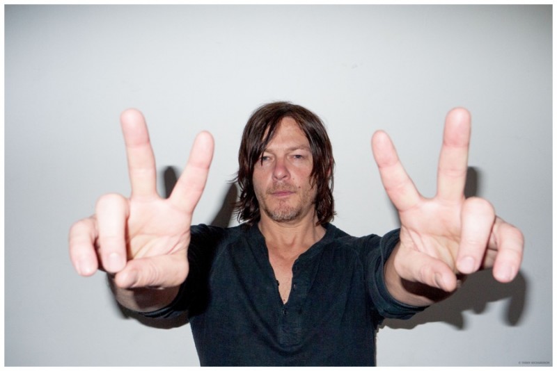 Norman Reedus throws up peace signs.
